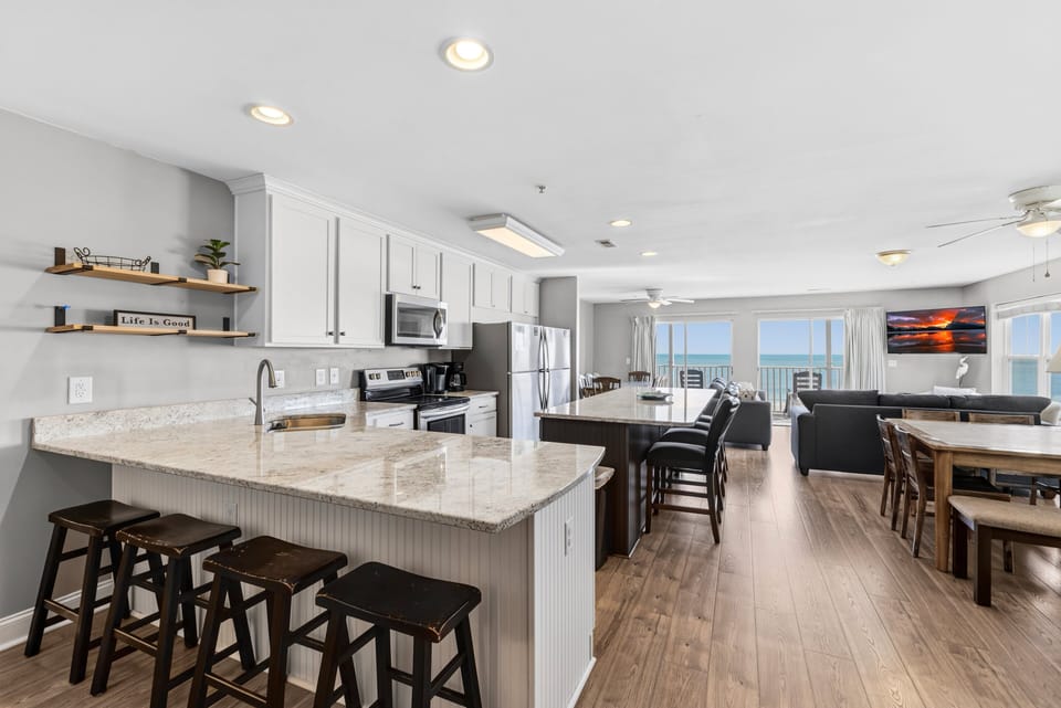 Full Kitchen - Kitchen with full appliances including refrigerator, stove, and microwave, along with cookware for preparing meals.