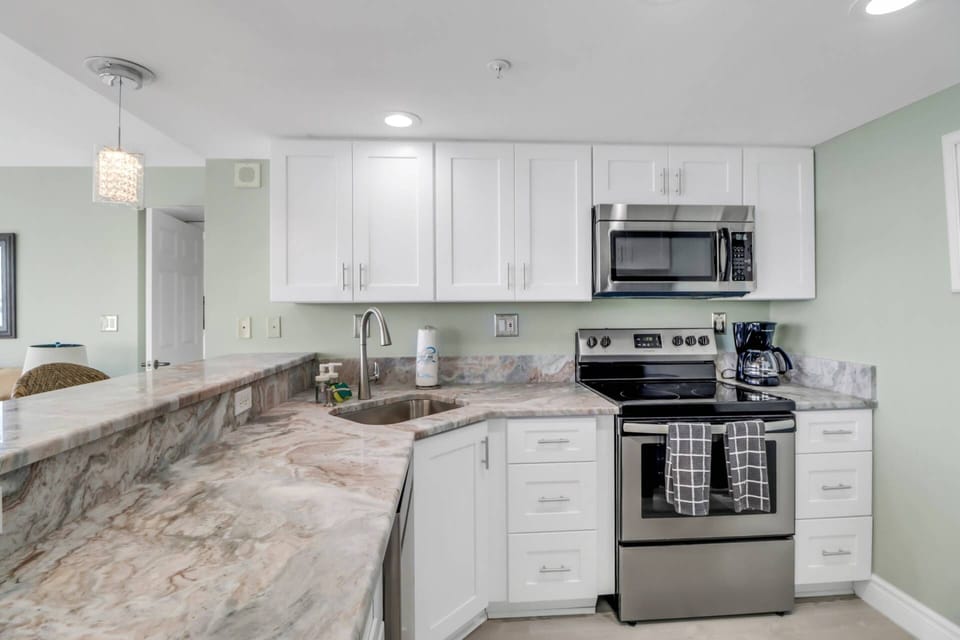 The kitchen comes well equipped with granite counters, modern cabinetry, new appliances, cookware and dinnerware.