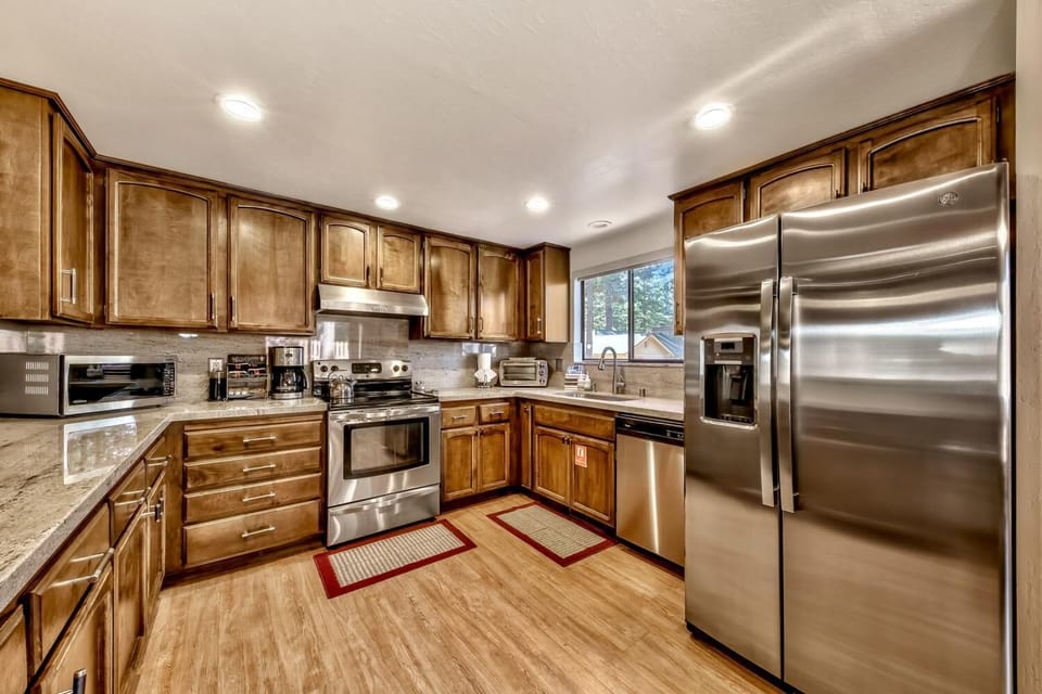 Cook memorable meals in your fully equipped kitchen, featuring granite counters, stainless steel appliances, and warm wood finishes.
