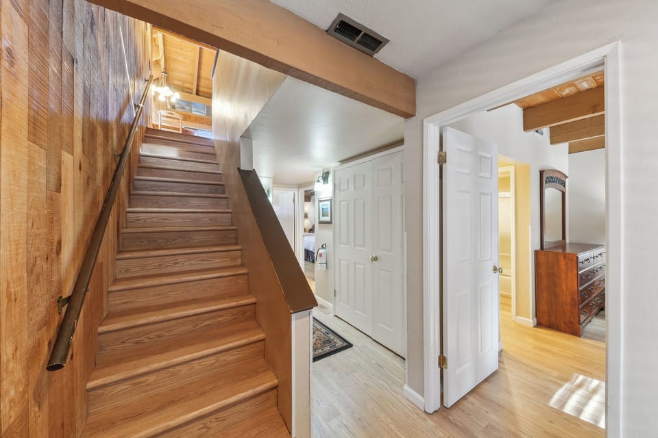 Step into the welcoming entryway where warm wood tones and exposed beams create an inviting atmosphere for your stay.