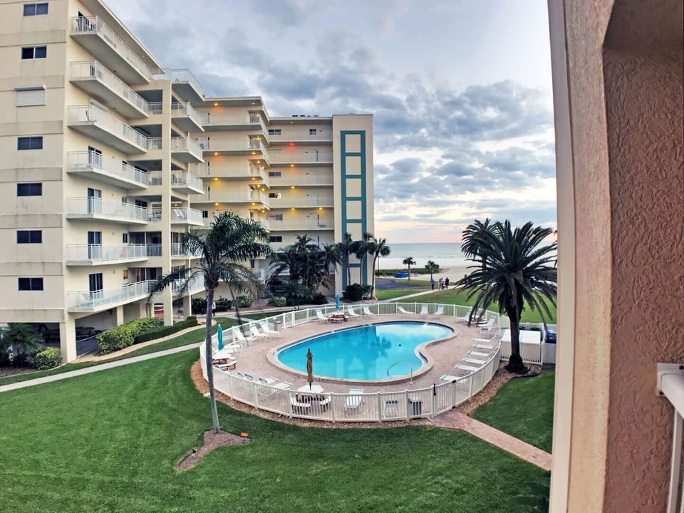 Building exterior with community pool and grounds from a distance