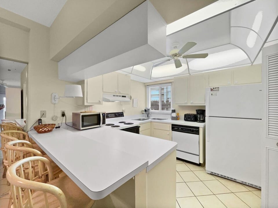 Kitchen with white countertops, cabinetry, and appliances