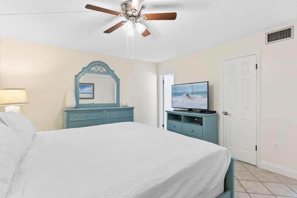 Charming master bedroom with king size bed, TV, soothing colors and a cozy retreat feel