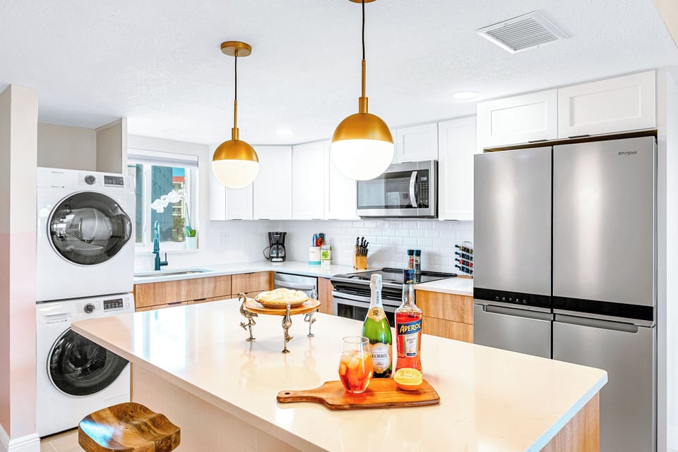 A bright modern kitchen with a washer and dryer for your convenience