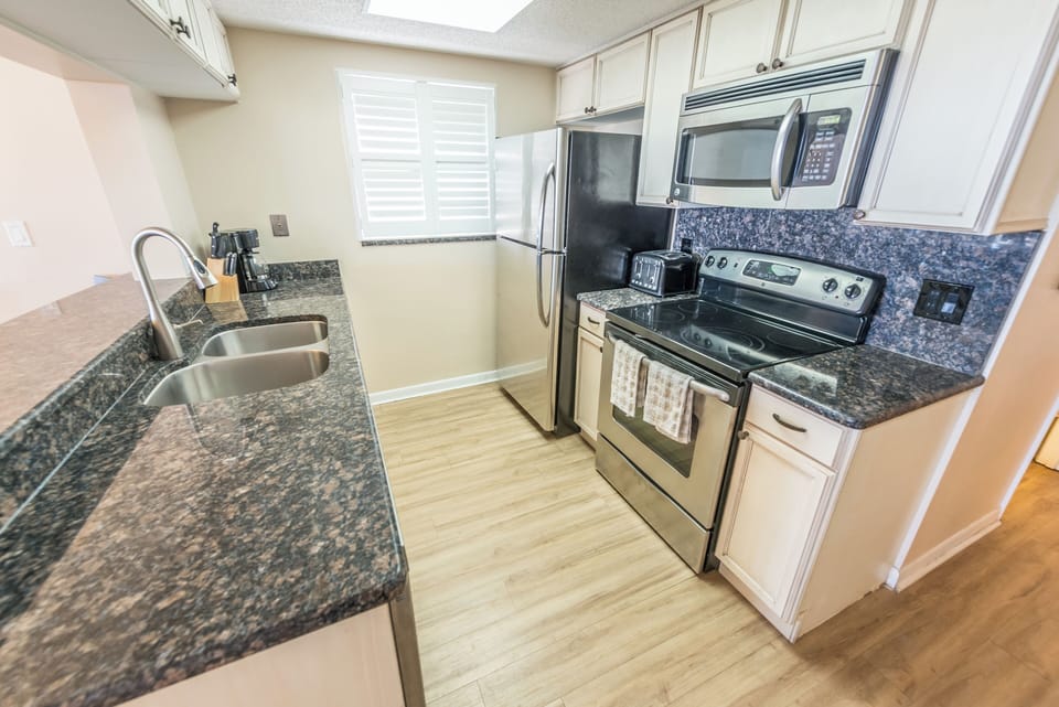 Fully equipped kitchen with sleek granite countertops and stainless steel appliances