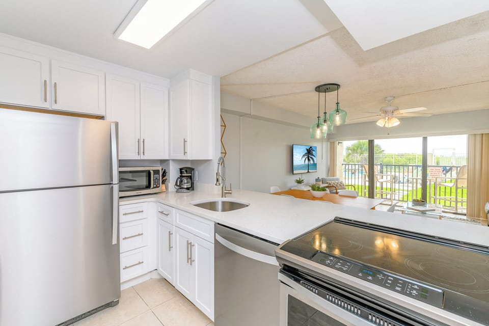 Cook with a view! This sleek kitchen flows into the living area and out to the poolside patio