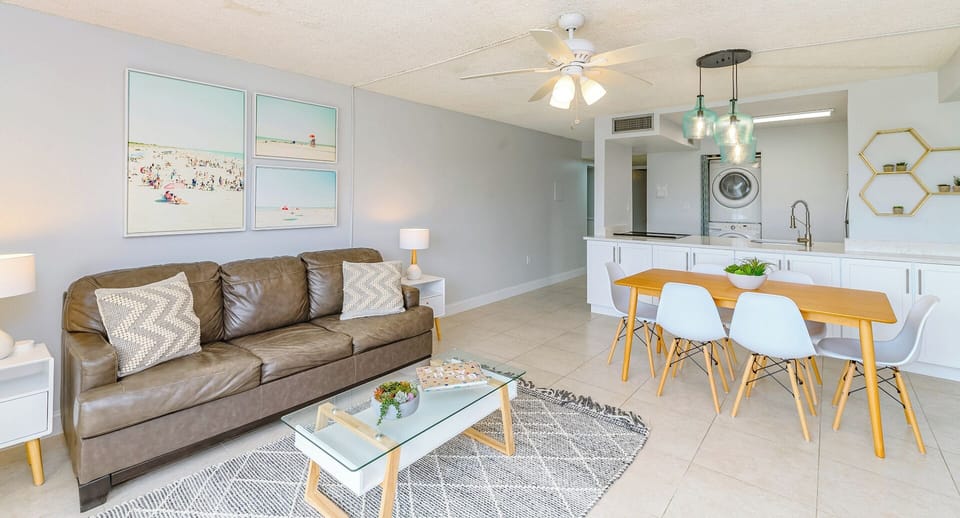 Kick back in this cheerful living space with a comfy leather couch, chic decor, and a peek of the full kitchen and in-unit laundry for effortless convenience.