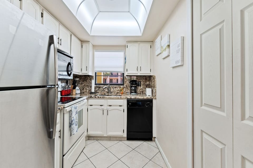 Bright and open galley kitchen with modern white cabinetry and plenty of space.