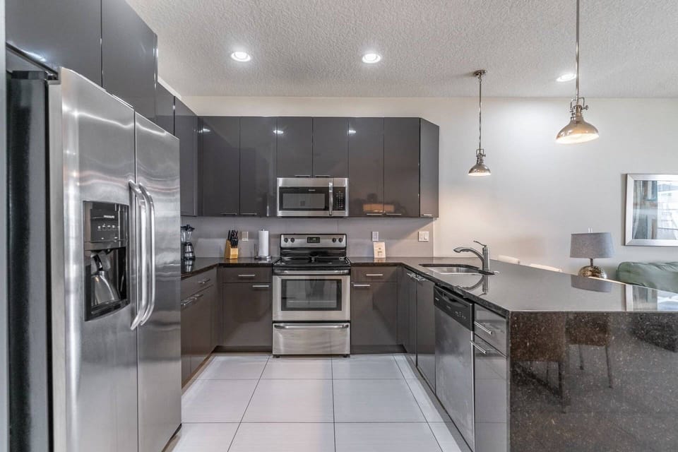 Modern kitchen with granite waterfall counters and stainless steel appliances