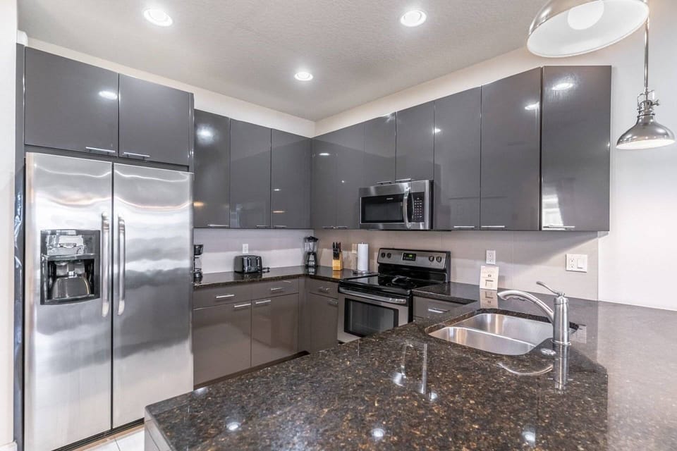 Modern kitchen with granite waterfall counters and stainless steel appliances