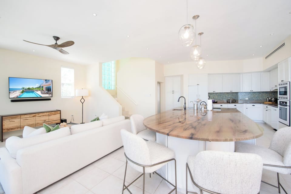 Open concept kitchen and living area equipped with an HD television and sound bar. 