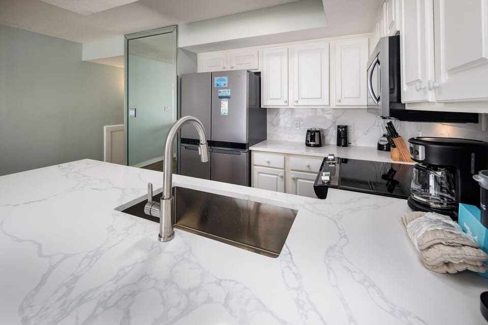 Kitchen - Featuring a quartz island and backsplash.