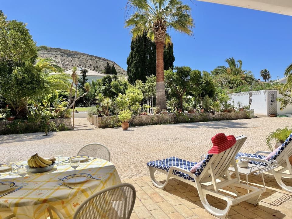 Front patio at Casa da Figueira provides shade and view of large tropical garden