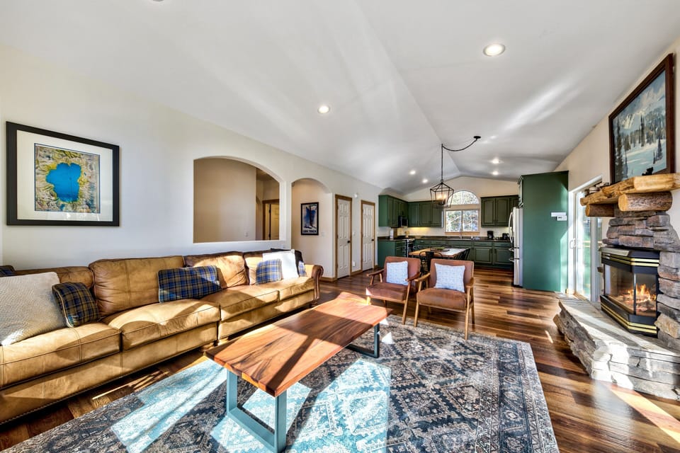Sink into plush leather seating by your crackling stone fireplace, where rustic charm meets modern comfort in this inviting open-concept retreat.