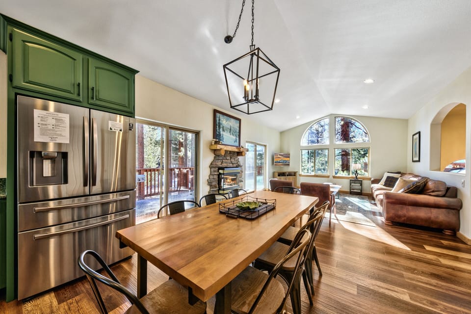 Gather around the beautiful wood dining table in this open-concept space, where your group can share meals while enjoying the cozy fireplace and forest views.