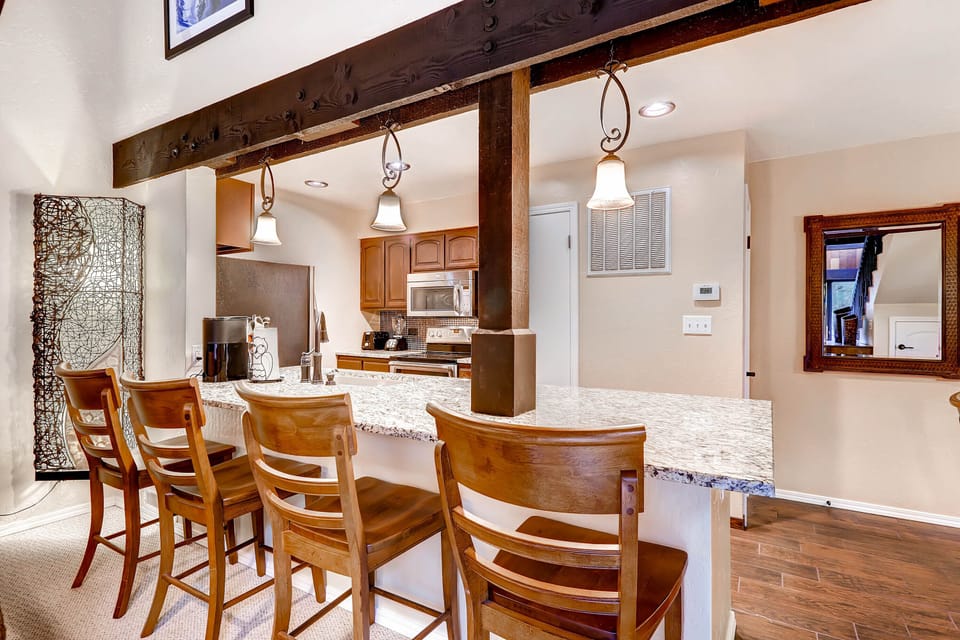 You'll love the rustic beam accents and granite breakfast bar, perfect for morning coffee or evening cocktails with friends.