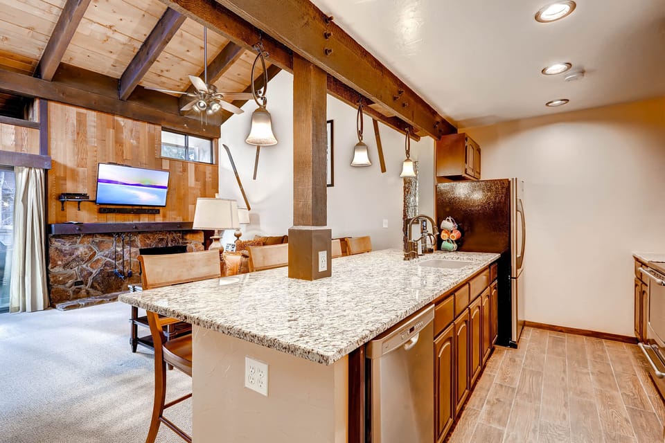 Your spacious mountain kitchen features granite countertops, exposed beams, and pendant lighting, perfect for preparing memorable meals together.