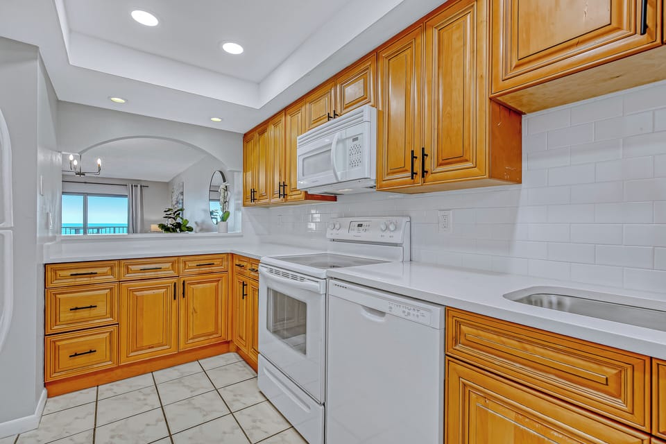 Fully equipped kitchen with wooden cabinetry, modern appliances, and ample counter space.