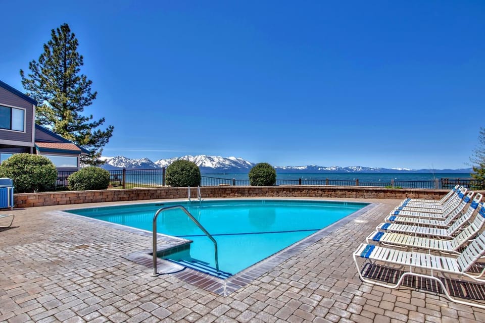 Stunning Lake Tahoe property with outdoor pool featuring breathtaking mountain views and pristine blue waters.