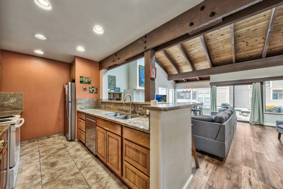 Cook and connect in this beautiful open-concept kitchen with exposed beams, granite counters, and seamless flow to your living space.