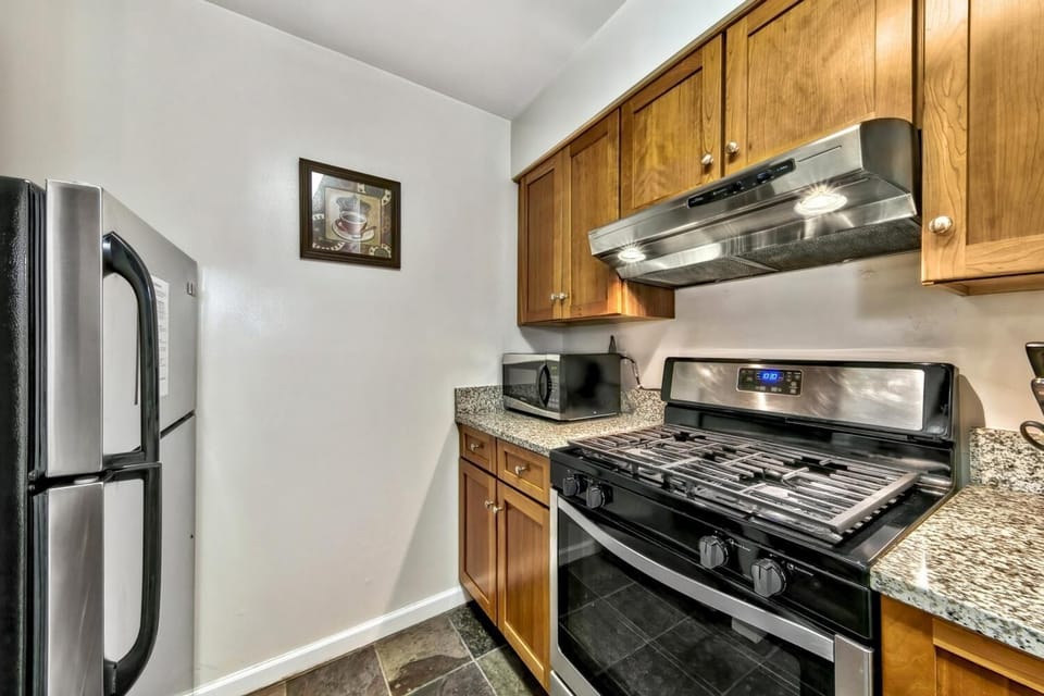 Your fully equipped kitchen features stainless steel appliances, warm wood cabinets, and granite countertops - perfect for preparing home-cooked meals during your stay.