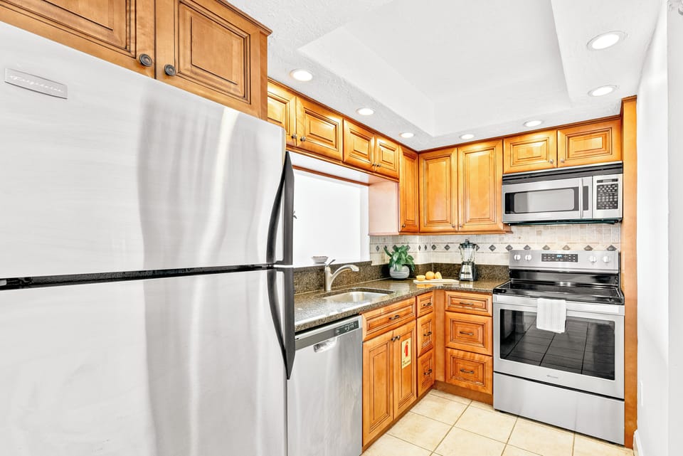 Fully stocked kitchen with stainless steel appliances and wood cabinetry