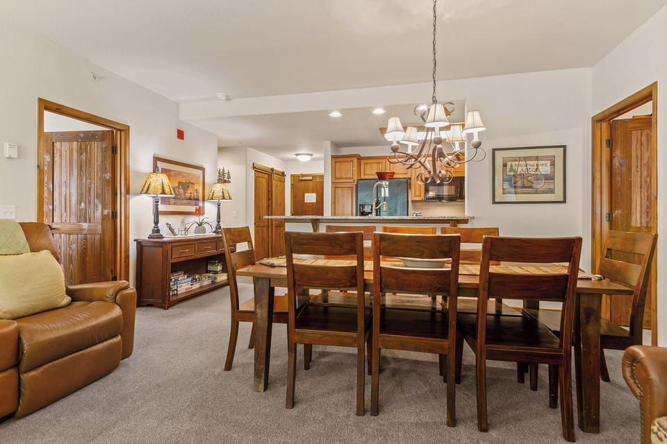Gather around the large dining table for memorable meals together, with a fully equipped kitchen ready for your culinary adventures and a cozy living space nearby.