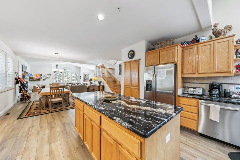 Your spacious kitchen island becomes the heart of your stay, with granite counters and warm wood cabinets creating the perfect gathering spot.