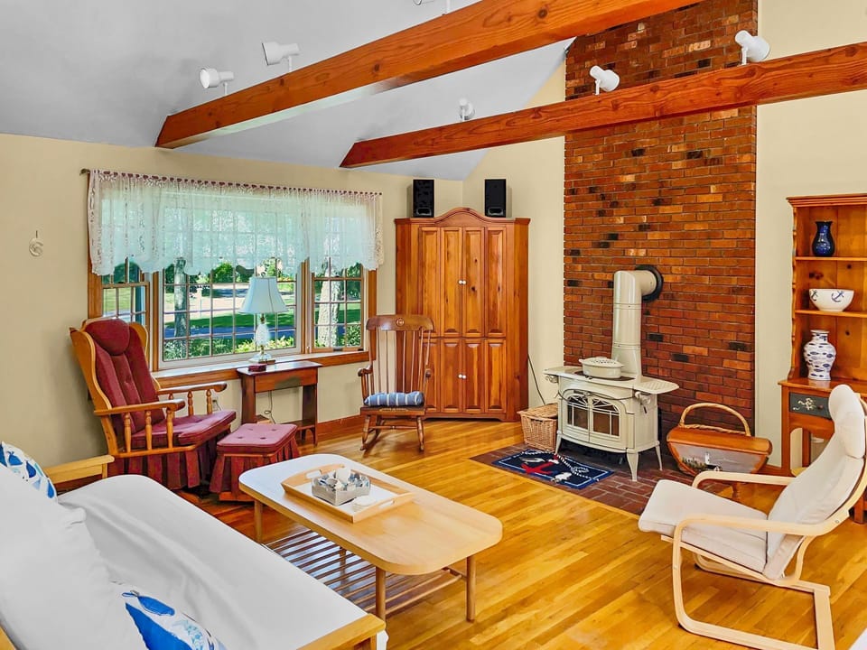 Living area with cozy seating around a hearth and flat screen TV that can be hidden for encouraging conversation