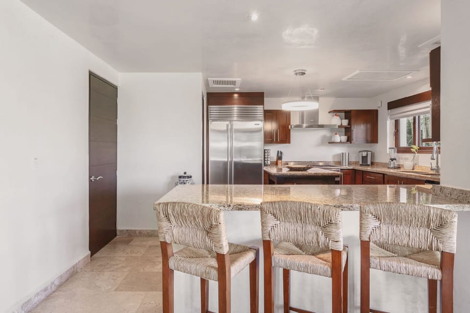 The open kitchen area has a beautiful bar area with 3 seats.