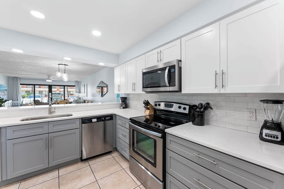 Cook with ease in this fully stocked kitchen featuring stainless steel appliances and a crisp two-tone cabinet design