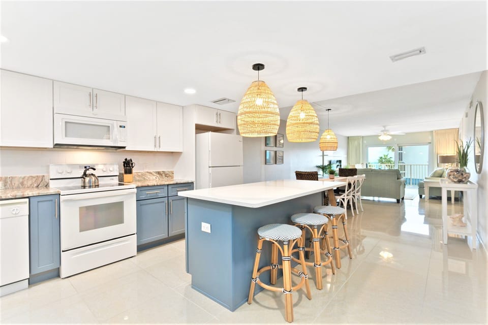 Stunning modern open-concept kitchen with a sleek island, stylish pendant lighting, and ample seating—perfect for gatherings.