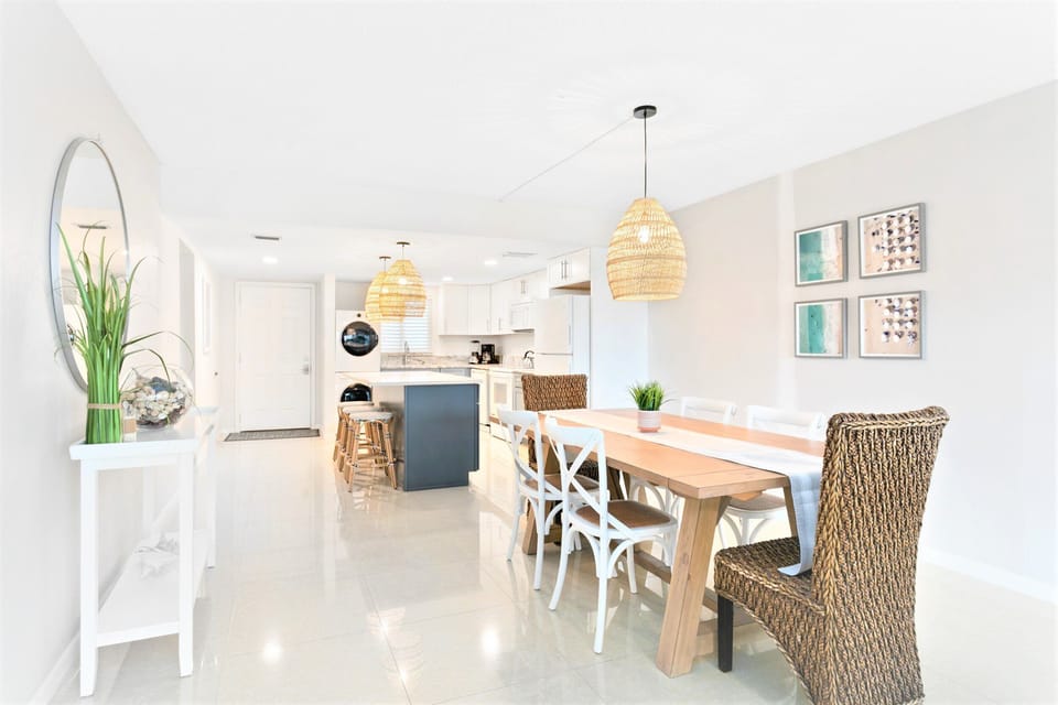 Open-concept dining room and kitchen, designed with a breezy coastal vibe and elegant lighting.