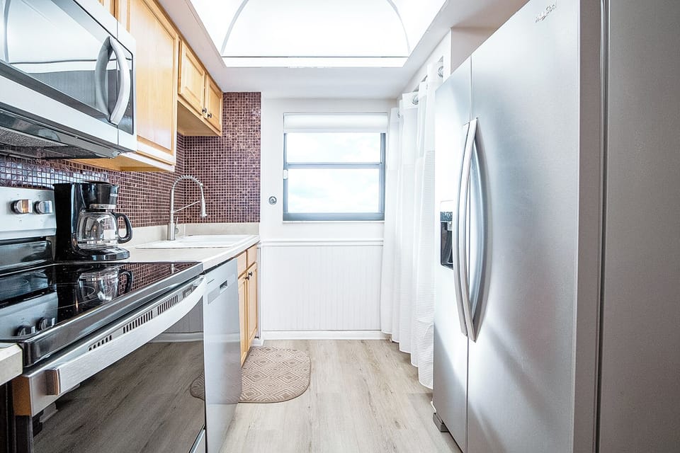 Modern kitchen is fully equipped with sleek appliances and natural light.