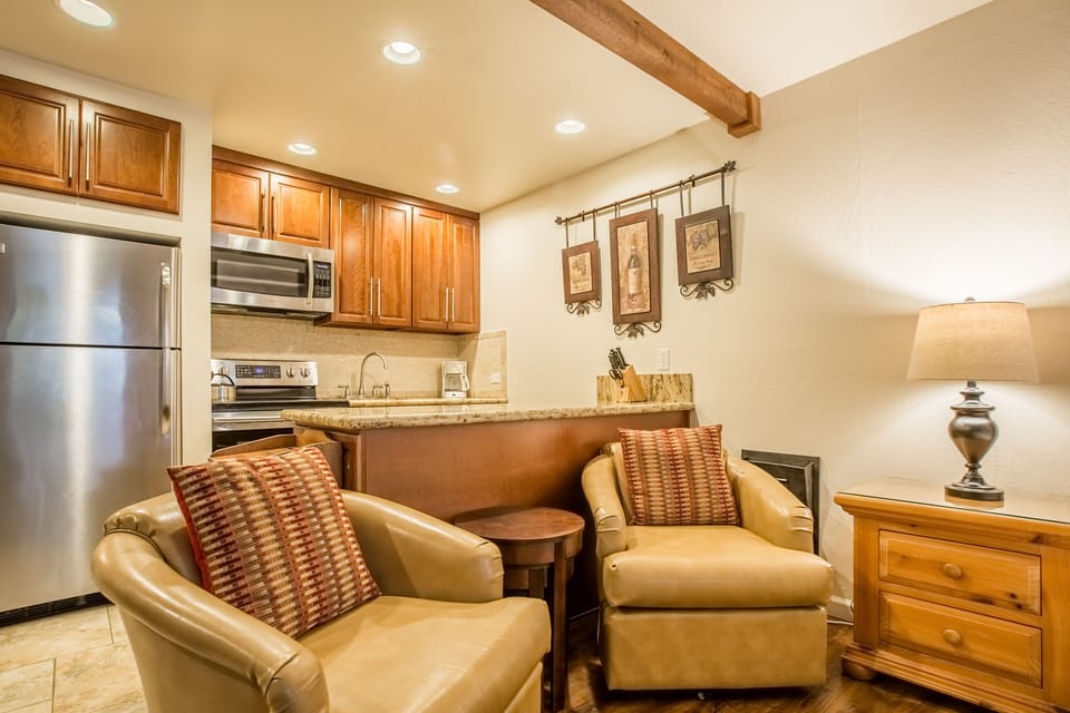 Unwind in your cozy living space featuring rich leather seating and a fully-equipped kitchen for your mountain getaway convenience.