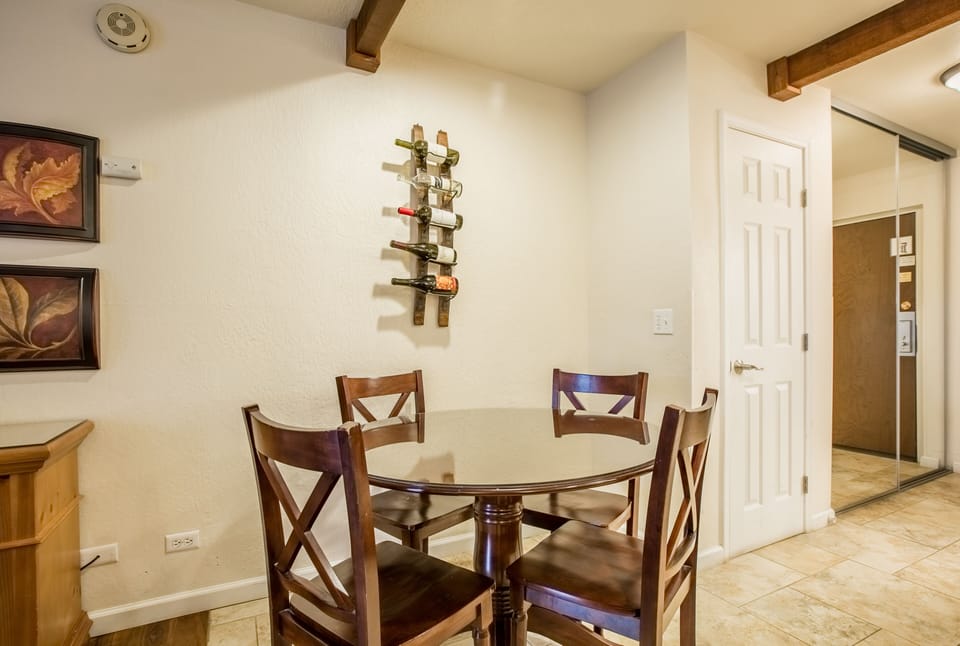 Gather around the dining table with rustic wood beams overhead, perfect for intimate meals and morning coffee together.