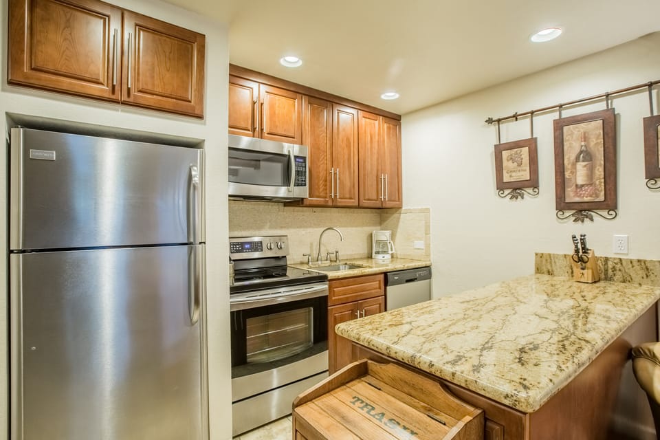 You'll love preparing meals in this fully equipped kitchen with granite countertops, stainless steel appliances, and warm wood cabinets.