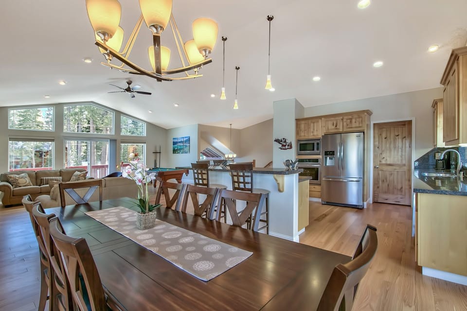 Your open-concept living space flows seamlessly from kitchen to dining to lounge, bathed in natural light from soaring windows.