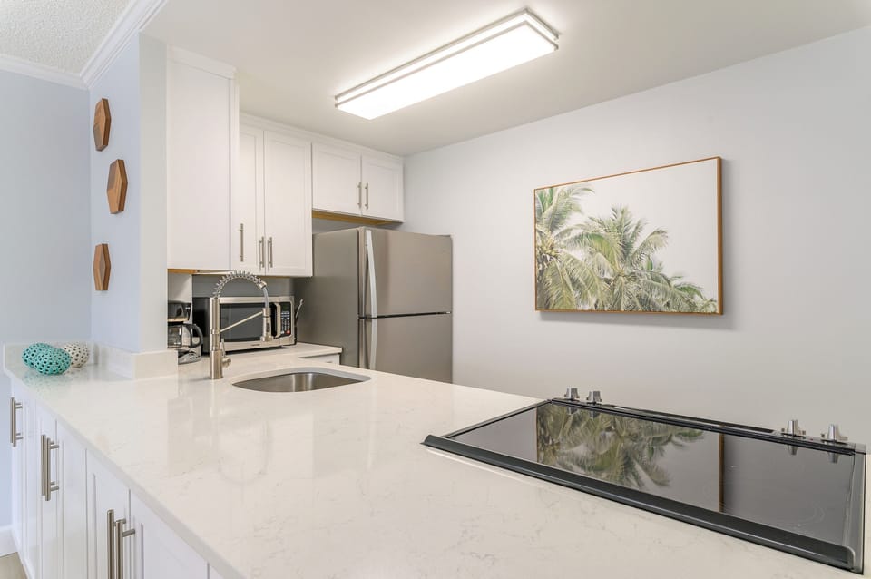 Sleek kitchen with white granite countertops and stainless steel appliances