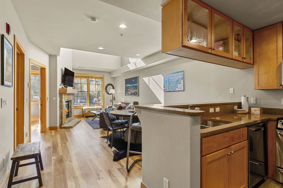 Your open-plan kitchen flows seamlessly into the living area, perfect for cooking while chatting with loved ones by the cozy fireplace.