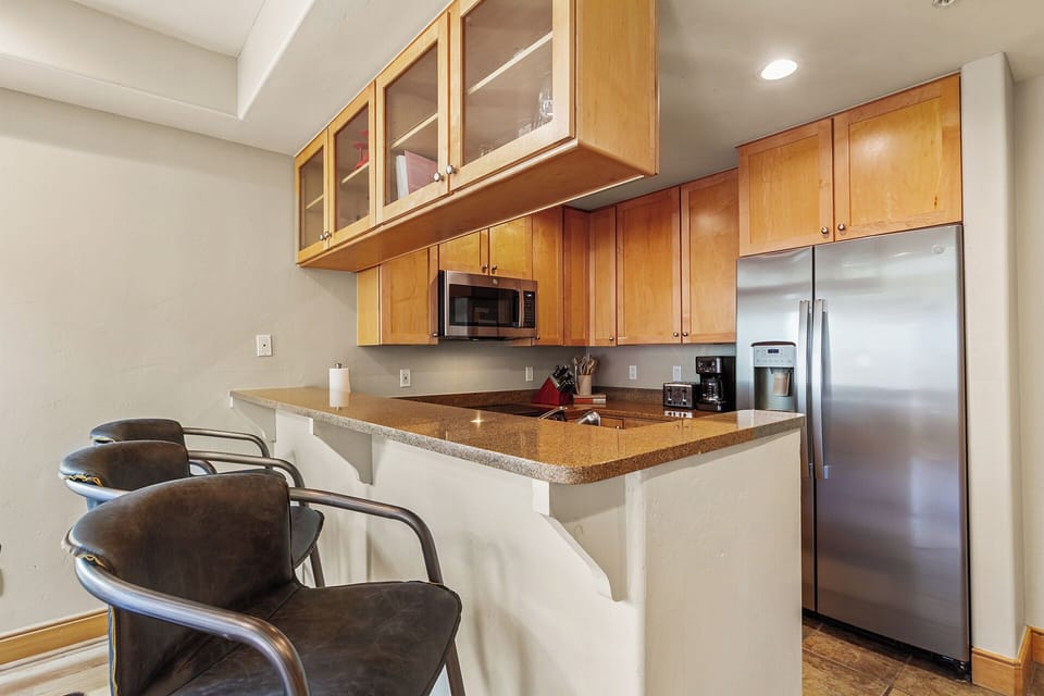 Your fully-equipped kitchen features modern appliances and a convenient breakfast bar where you can enjoy morning coffee.
