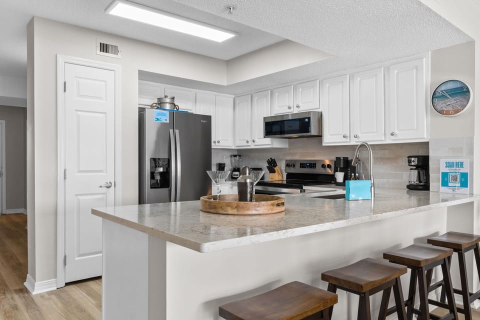 Kitchen - "Whether you’re gathering for a full family breakfast or a quick fuel-up before the beach, this home handles it all with ease. Enjoy the refined luxury of the living area, or pull up one of the four bar stools at the kitchen island for a casual bite. Between the ample lounge seating