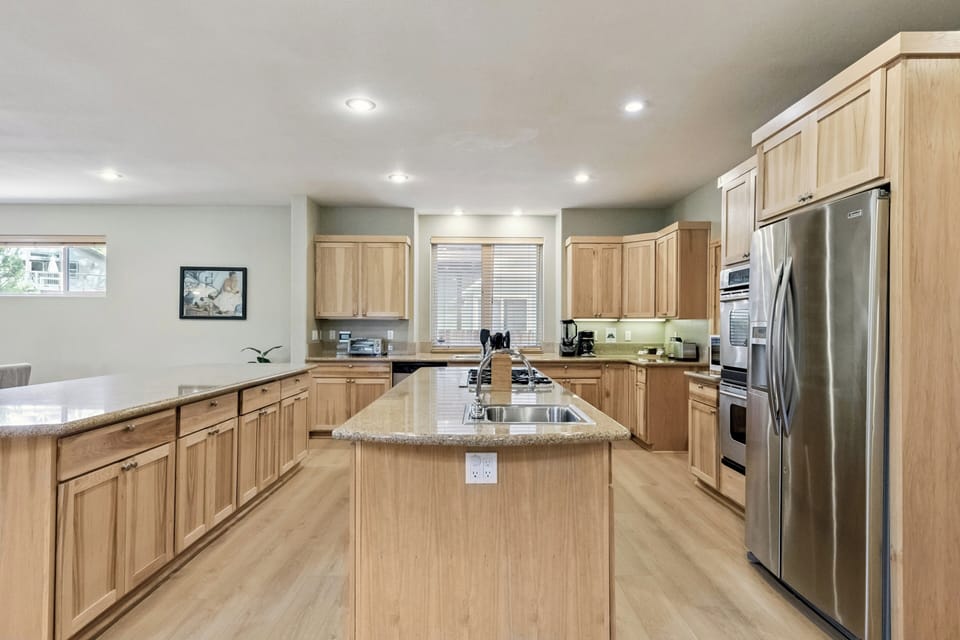 Cook with ease in this spacious kitchen featuring warm wood cabinetry, granite countertops, and stainless steel appliances.