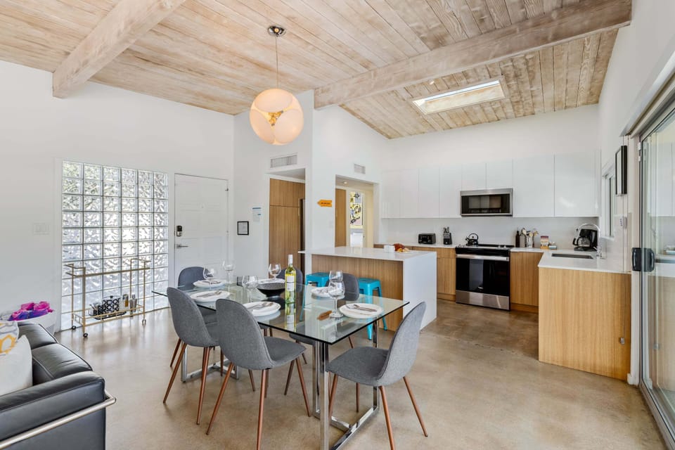 Step into your modern open-plan haven where exposed wood beams meet sleek design. Cook, dine, and relax in this light-filled space with contemporary furnishings.