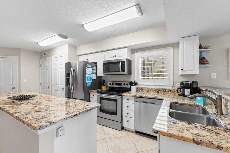 Kitchen - Stainless steel appliances, white cabinetry, endless counter space