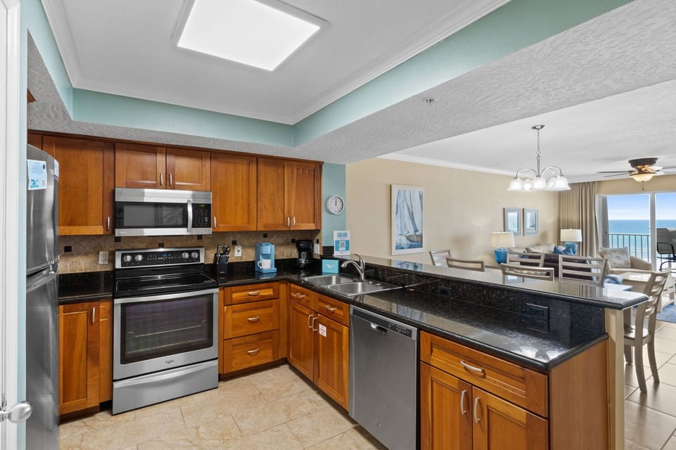 Kitchen - This updated kitchen is fully equipped for all of your cooking needs. Who wouldn't want to prepare a meal alongside our enticing emerald waters! Everything you need is right at your fingertips. Cherry stained cabinets and granite counter tops make up this charming palette.