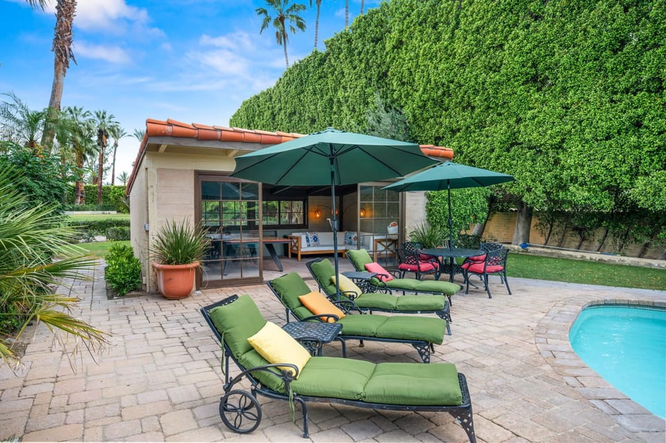 A private oasis awaits with lush lawn, shaded loungers, and poolside patio ideal for morning coffee or sunset cocktails.