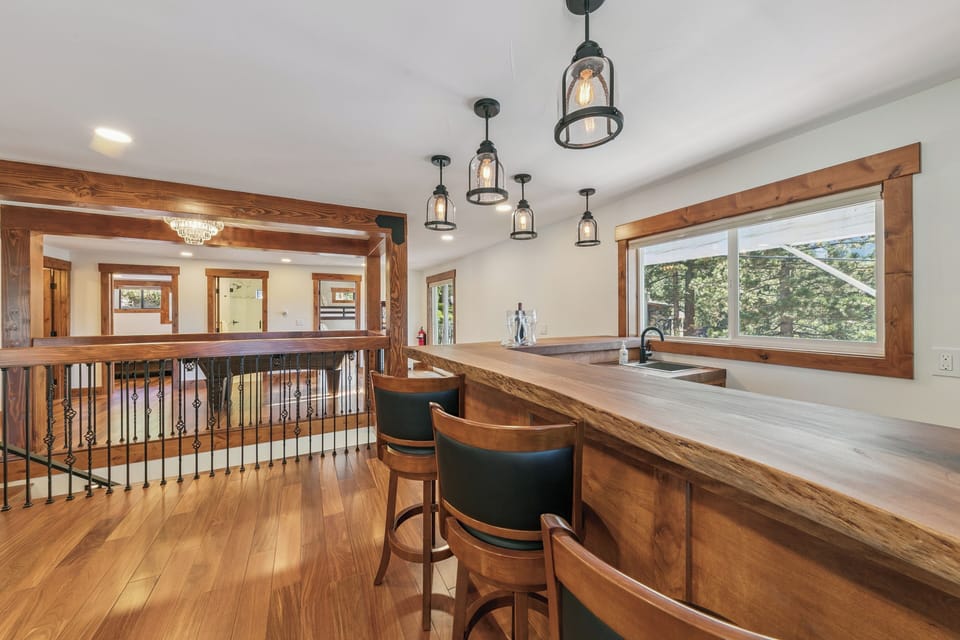 Gather with friends at this handcrafted wooden bar, where warm pendant lighting creates the perfect atmosphere for memorable evenings together.