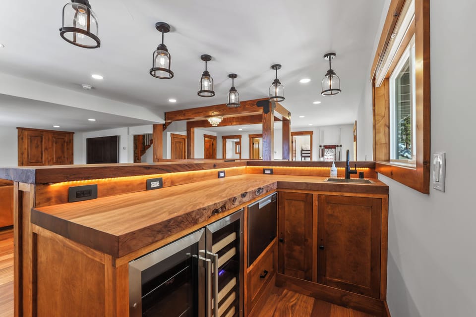 Your gourmet kitchen features warm wood cabinetry, elegant pendant lighting, and premium appliances perfect for creating memorable meals.