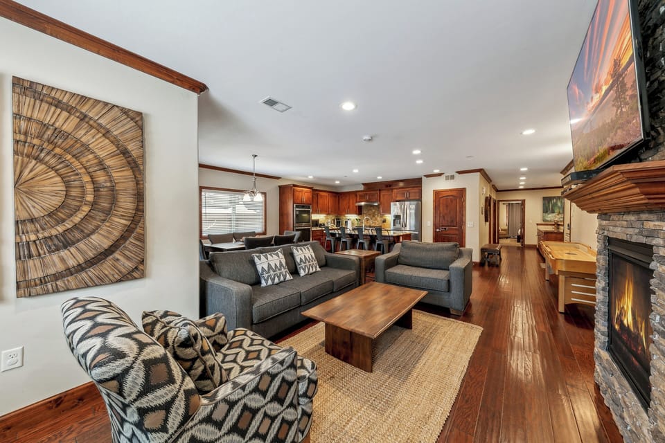 Relax in your spacious living room with cozy seating, warm fireplace, and open-concept design flowing into the fully equipped kitchen.